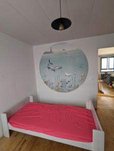 a bedroom with a red bed and a painting on the wall at Charmant appartement T3 in Trappes