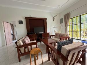 een woonkamer met een tafel en stoelen en een televisie bij A’famosa Villa D’amour in Melaka