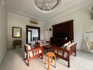 een woonkamer met een tafel en stoelen bij A’famosa Villa D’amour in Melaka