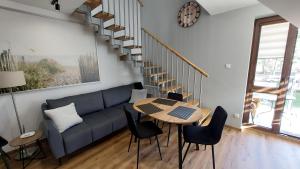 クリニツァ・モルスカにあるAPARTAMENT BULWAR PRZY PLAŻY - 100m od plażyの青いソファとテーブルのあるリビングルーム