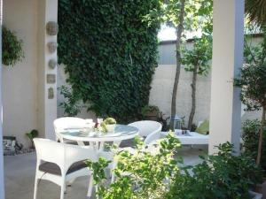 patio z białym stołem i krzesłami w obiekcie Wohnung in Vodice mit Terrasse, Garten und gemeinschaftlichem Pool w mieście Vodice