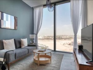 a living room with a couch and a large window at Budget Staying - Comfortably and Luxuriously in Dubai in Dubai