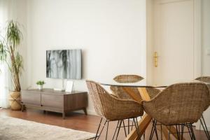 a dining room with a table and wicker chairs at Cozy Sea View Apartment near City and Airport in Ponta Delgada