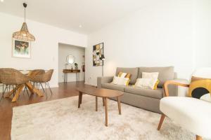 a living room with a couch and a table at Cozy Sea View Apartment near City and Airport in Ponta Delgada