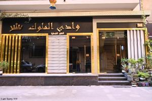 een gebouw waar een vrouw buiten staat bij وادى الملوك للشقق الفندقية in Mansoura