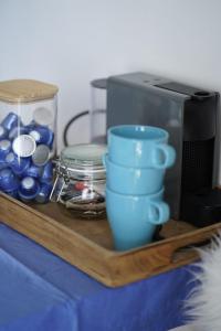a wooden tray with blue cups and a microwave at L'infini Sea Shell apartment Zubovići in Zubovići