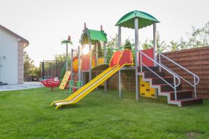 a playground with a slide in a yard at Bedroom - domek nr 1 in Łeba