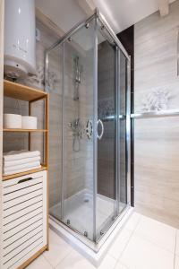 a shower with a glass enclosure in a bathroom at Bedroom - domek nr 1 in Łeba