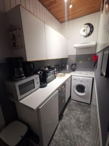 a kitchen with a microwave and a washing machine at Appartement avec Balcon au 1er étage Vue latérale Mer à 50 mètres de la plage à Mers les Bains. in Mers-les-Bains