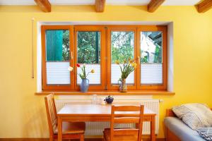 mesa y sillas en una habitación con ventana en Time to relax and enjoy nature, en Grünwald