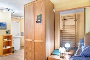 a living room with a blue couch and a wooden closet at Milchtütenzimmer - Upcycling in Grünwald