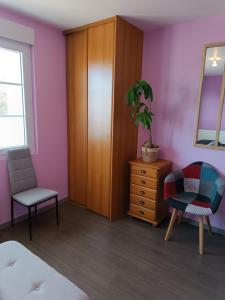 une chambre avec une armoire, une chaise et une plante dans l'établissement Appartement Cosy proche Mer, à Gouville-sur-Mer