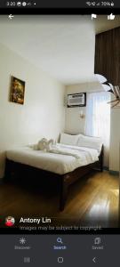 ein leeres Bett in einem Zimmer mit Fenster in der Unterkunft BELLADAMA HOTEL in San Carlos