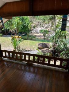 a wooden porch with a view of a garden at ท่าเเพ รีสอร์ท in Ban Tha Phae