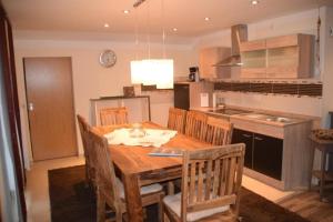 - une cuisine avec une table et des chaises en bois dans l'établissement Appartement in Arrach mit Großem Balkon, à Arrach