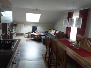 Il dispose d'une cuisine et d'un salon avec un canapé et une table. dans l'établissement Appartement in Arrach mit Großem Balkon, à Arrach