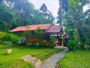 a house with a red roof in a forest at ท่าเเพ ฟอเรสต์ รีสอร์ต in Ban Tha Phae