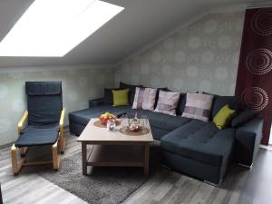ein Wohnzimmer mit einem blauen Sofa und einem Tisch in der Unterkunft Appartement in Arrach mit Großem Balkon in Arrach