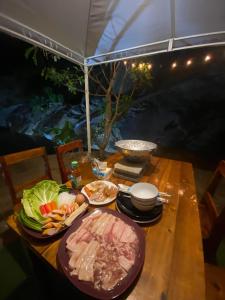 una mesa con platos de comida encima en ท่าเเพ รีสอร์ท en Ban Tha Phae
