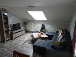 a living room with a blue couch and a tv at Appartement in Arrach mit Großem Balkon in Arrach