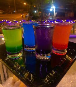 un grupo de cuatro vasos coloridos sentados en una bandeja en ท่าเเพ รีสอร์ท en Ban Tha Phae