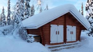 Cabaña de madera con nieve en el techo en Verträumtes Blockhaus mitten im Wald, en Rauhala