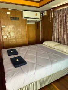 Una cama en una habitación con dos toallas. en ท่าเเพ รีสอร์ท en Ban Tha Phae