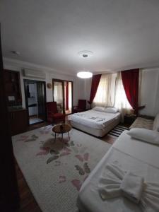 ギョジェクにあるJasmin Apart Otelのベッド2台とリビングルームが備わるホテルルームです。