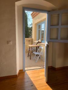 a door to a room with a table and a chair at Apartamento en Casa del Siglo XVI con caballos in Ametlla