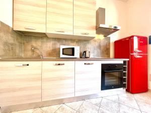 uma cozinha com um frigorífico vermelho e um micro-ondas em Le Corti Sarde 102 em Bari Sardo