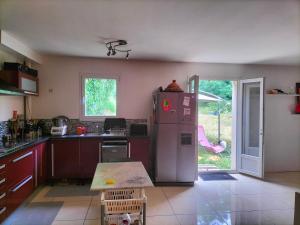 a kitchen with a refrigerator and a table in it at chez H&M in Saint-Cyr-lʼÉcole