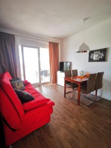 - un salon avec un canapé rouge et une table dans l'établissement Nette Wohnung in Vodice mit Großer Terrasse und Strand in der Nähe, à Vodice