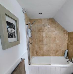 Abernethy的住宿－Pitcaithly Cottage，带淋浴和浴缸的浴室