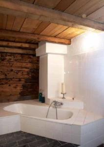 a bath tub in a room with a wooden ceiling at Das spezielle Ferienhaus Heidi - b48536 in Maienfeld