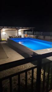 a large blue swimming pool at night at Apartments Calimero in Mostar