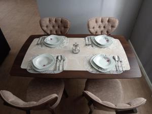 a table with two chairs and a table with plates and napkins at Apartments Calimero in Mostar