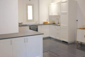 a white kitchen with white cabinets and a window at Luxury Loft Apartment in Kuwait