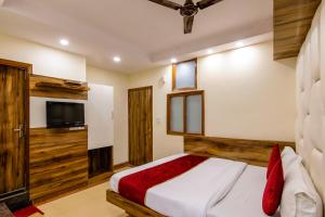 a bedroom with a bed and a flat screen tv at The Price Hotels Main Bazar Pahar Ganj New Delhi in New Delhi