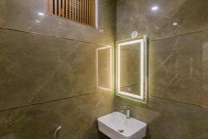 a bathroom with a sink and a mirror at The Price Hotels Main Bazar Pahar Ganj New Delhi in New Delhi
