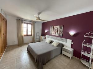 a bedroom with a bed and a purple wall at Mitjaneta - Apartamento con piscina in Cala en Blanes +26 photos