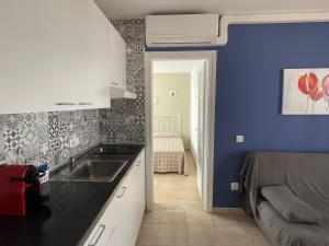 cocina con fregadero y pared azul en Mitjaneta Apartamento con piscina en Cala en Blanes