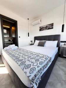 1 dormitorio con 1 cama grande con manta blanca y negra en LUXURY VILLAS AKTI, en Aliveri