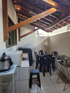 a kitchen with black chairs and a table at Casa de temporada 1000mts do thermas in Olímpia