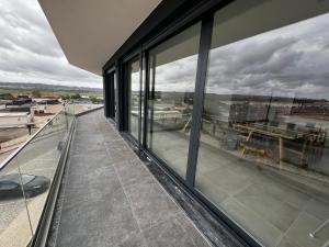 a balcony with windows and a view of a city at Modern spacious apartment with rooftop pool in São Martinho do Porto