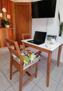 un ordenador portátil sentado en un escritorio con una silla en @946 en Pretoria