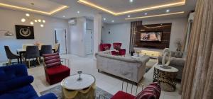 ein Wohnzimmer mit einer Couch und Stühlen und einem Tisch in der Unterkunft Luxury 3-Bed house in gated estate with pool Lekki in Maiyegun