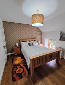 a bedroom with a large bed and a pendant light at Pitcaithly Cottage in Abernethy