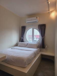 a bedroom with a large bed with a window at Line Bangkok Hostel in Bangkok