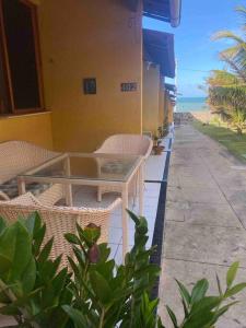 a patio with a table and chairs and the ocean at Sua casa na praia in Caucaia