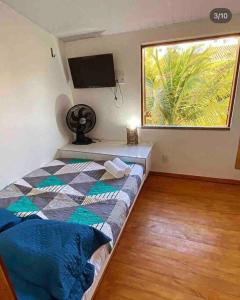 a bedroom with a bed and a large window at Sua casa na praia in Caucaia